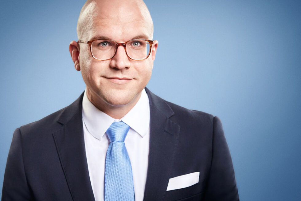 Businessportrait einer Frau im grauen Blazer vor hellem Hintergrund