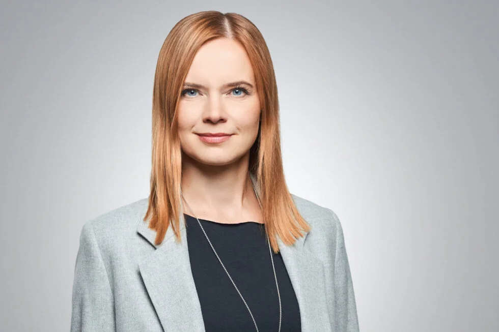 Businessportrait einer Frau im grauen Blazer vor hellem Hintergrund