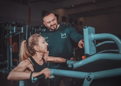 Personaltrainer bei der Geräteeinweisung einer Kundin